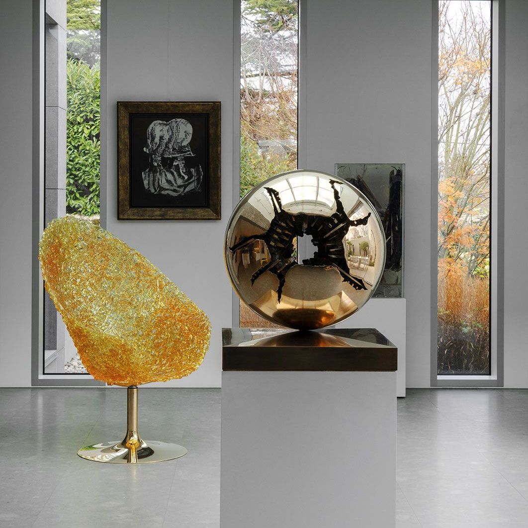   Margherita .&nbsp;la fauteuil en polycarbonate flanque une sculpture d&lsquo;Arnaldo Pomodoro 