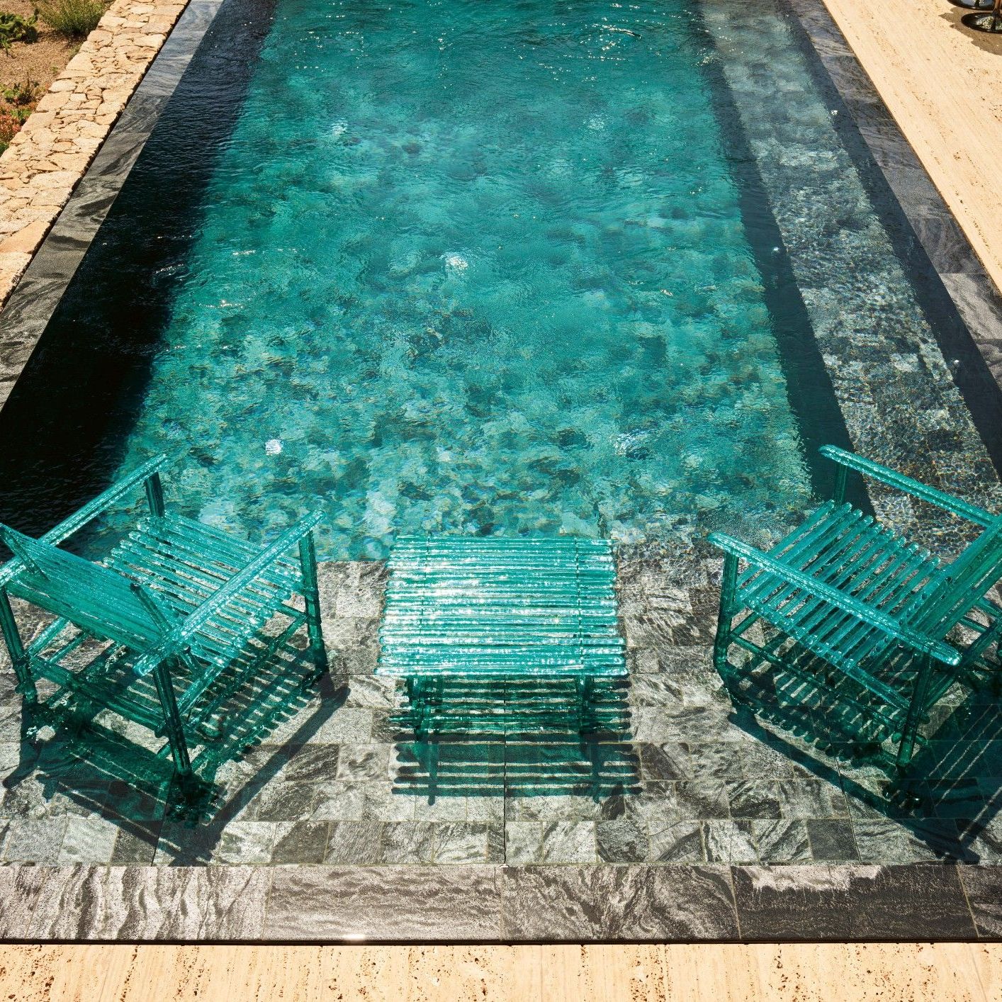  A&rsquo;mare. Lettini prendisole, tavoli e poltrone della collezione outdoor riflettono la luce del sole e i colori della piscina. 